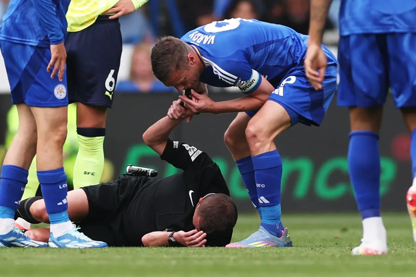 Moment Jamie Vardy attrape le poignet de l’arbitre et coup de sifflet pour arrêter le match tandis que officiel est sujet au sol